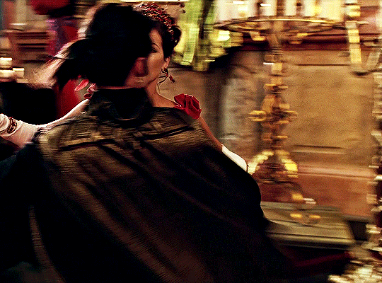 A GIF from the movie 'Van Helsing'. A man and woman in period dress dance in an ornate room. The man dips the woman in front of a mirror, which reveals that he has no reflection.
