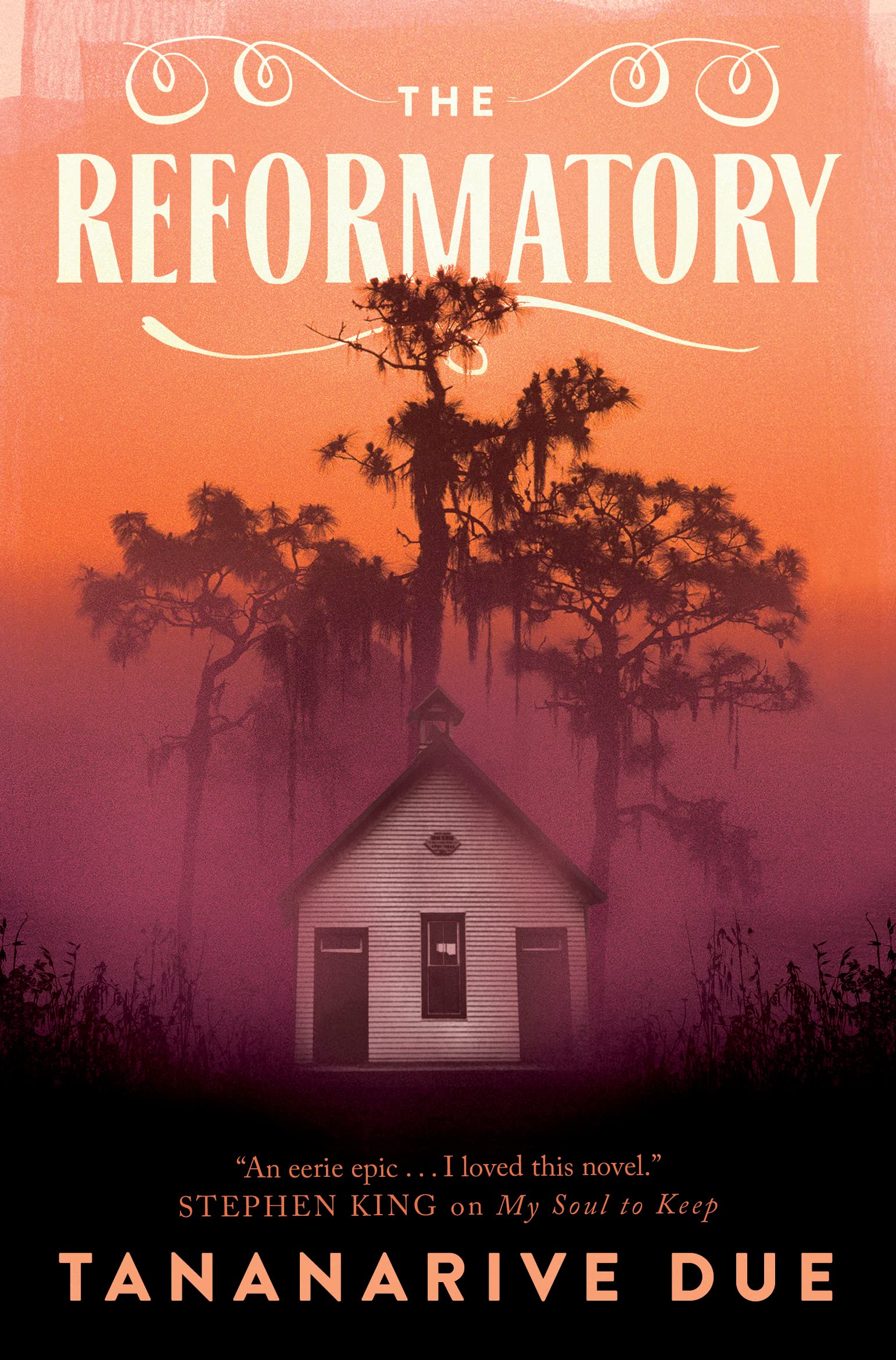 Book cover for 'The Reformatory' by Tananarive Due. A small white house sits underneath a large tree and an orange sky.