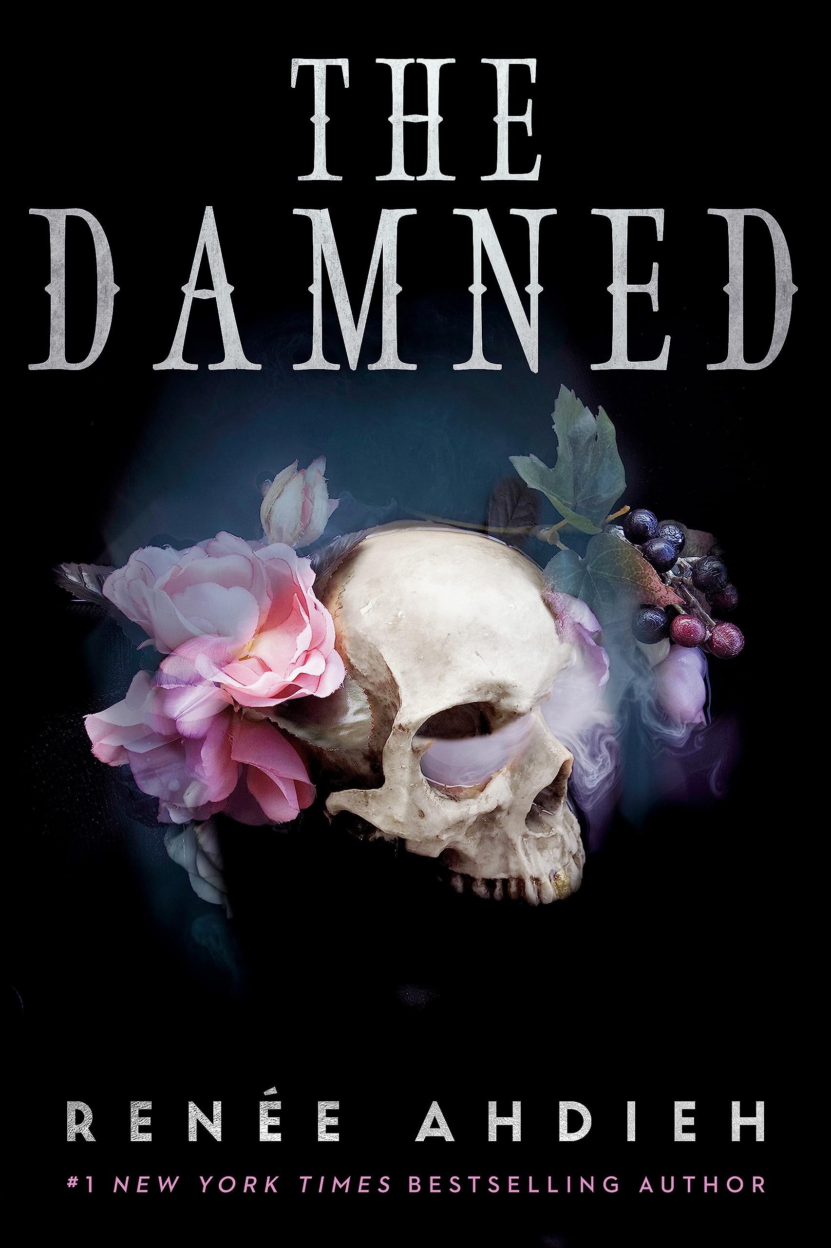 Book cover for 'The Damned' by Renée Ahdieh. The top half of a human skull can be seen against a black background with flowers surrounding it.